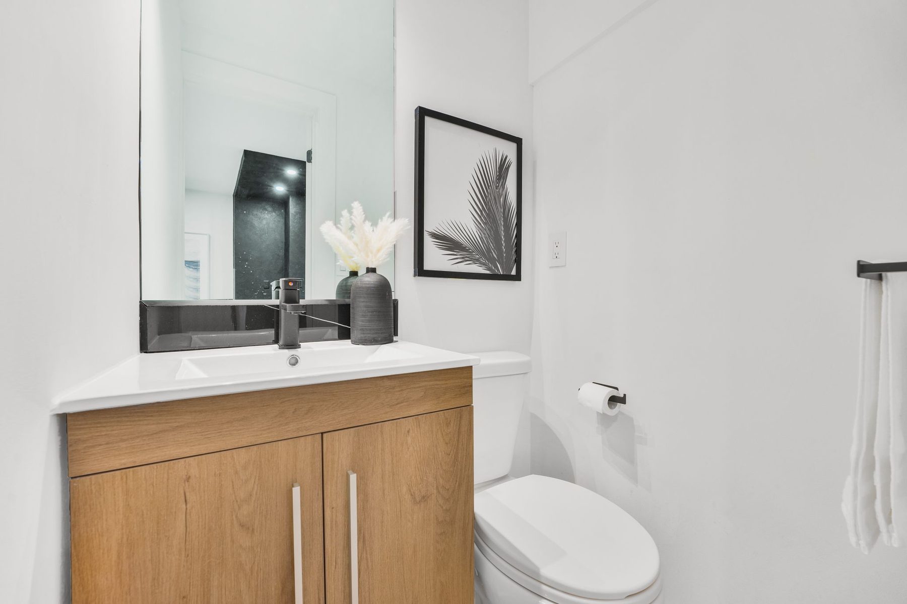 Bright powder room with a wood vanity and wall mirror
