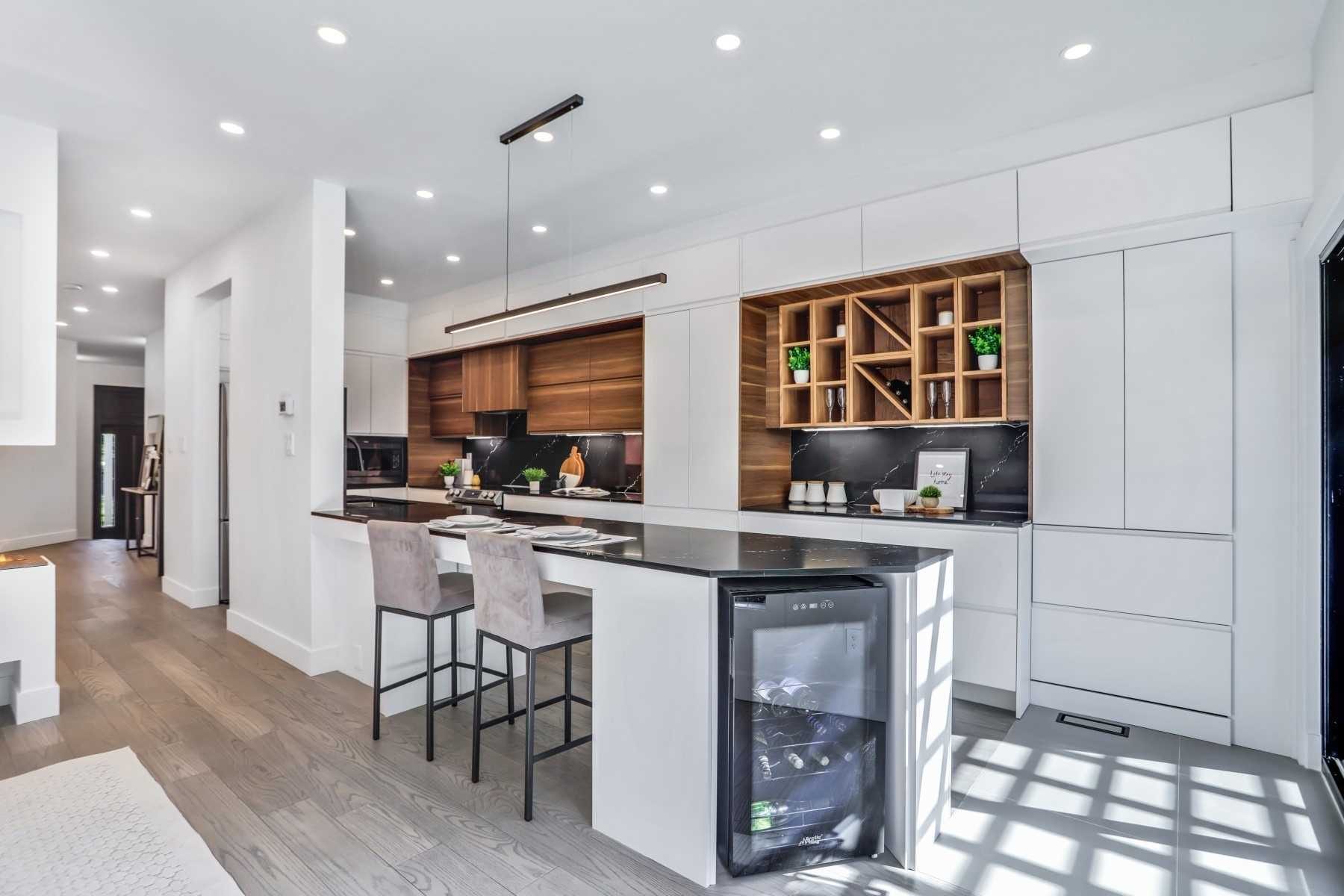 Bright white kitchen with warm wood cabinetry and peninsula seating