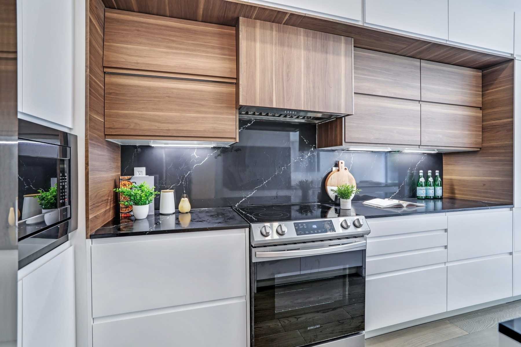 Wood and white kitchen cabinetry with a dark stone backsplash