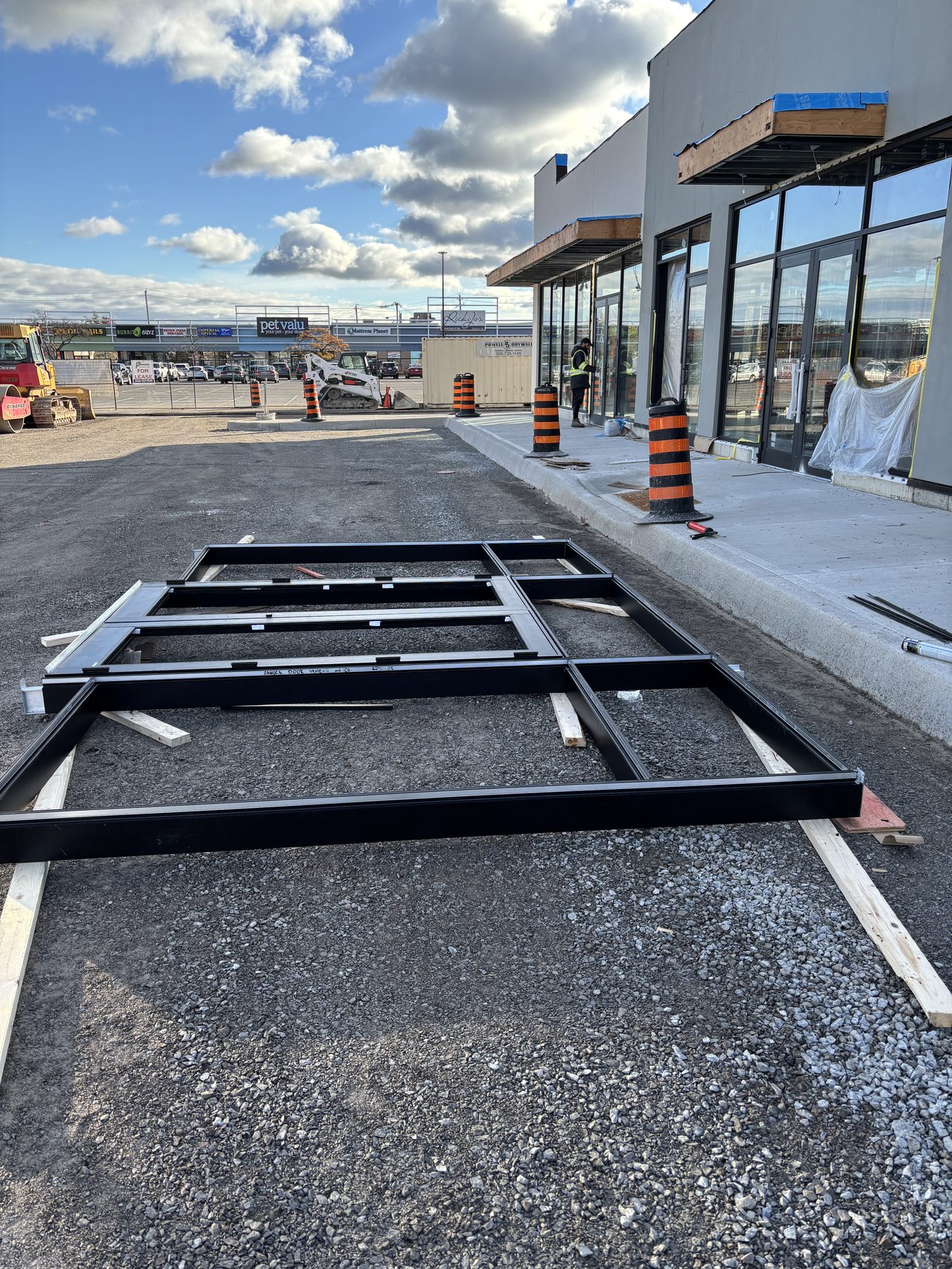Window and door frames staged beside a commercial installation