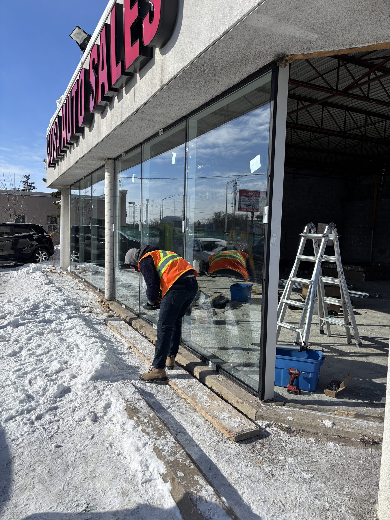 Crew installing full-height retail storefront glass